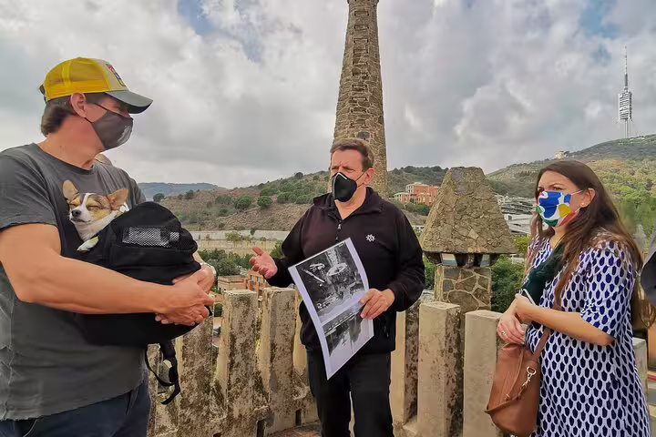 Visitors engage with a guide during a Colonia Guell and Casa Vicens private tour, showcasing historic architecture and scenic views.