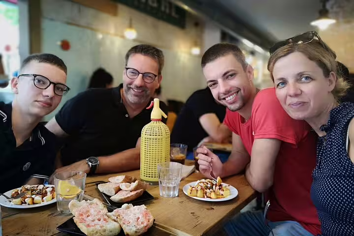 Group enjoying tapas at a cozy cafe, highlighting the vibrant local culture on the Colonia Guell & Casa Vicens private tour.