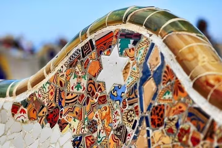 Close-up of colorful mosaic bench in Park Güell, showcasing Gaudí's iconic design in Barcelona tour.
