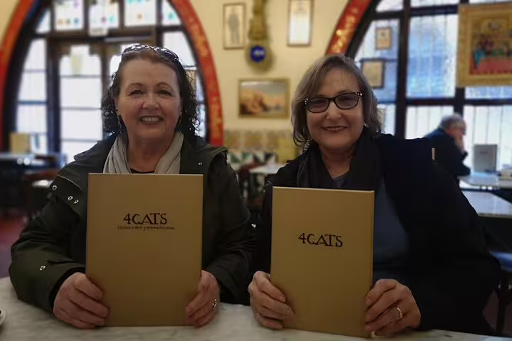 Two women enjoy a visit to the historic 4 Gats café in Barcelona, a highlight of the Gaudi and Sagrada Familia tour.