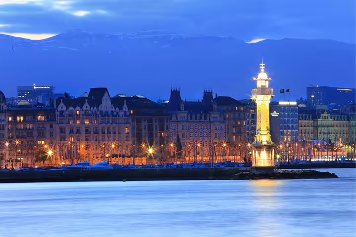 Geneva waterfront at dusk with lit lighthouse on Lake Geneva, perfect for a self-guided scavenger hunt tour