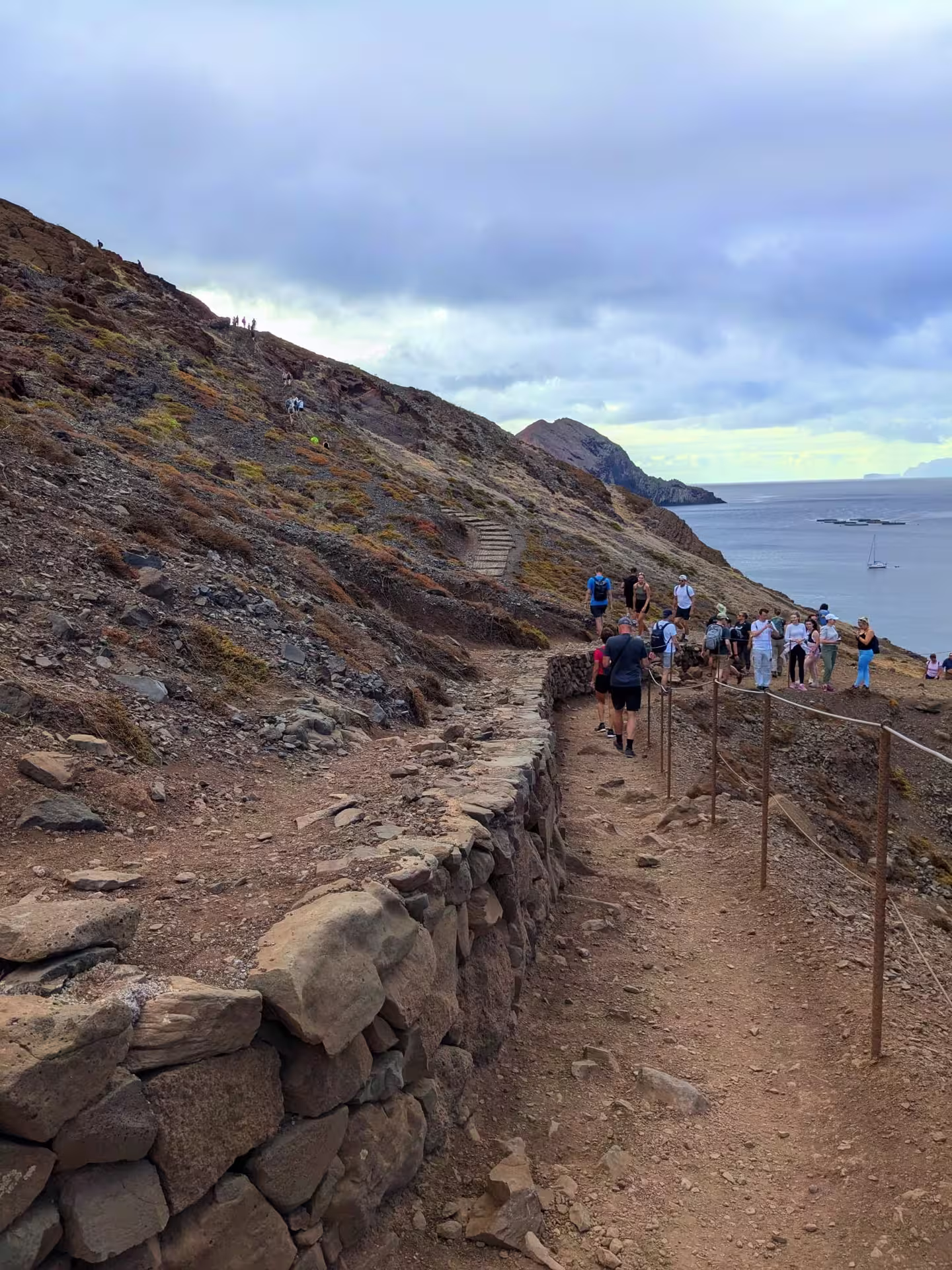 Hikers explore a rugged coastal trail with stunning ocean views on The Geological Hike tour.