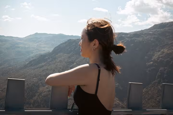 Person enjoying panoramic mountain views from a lookout point in Geres National Park under a clear blue sky.