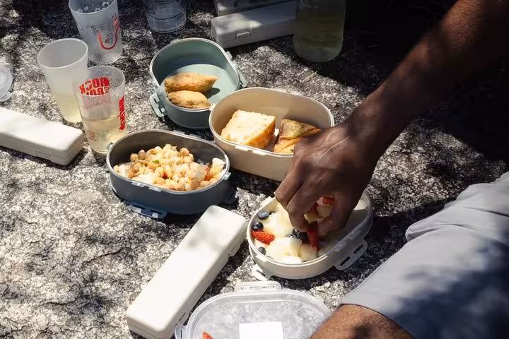 Picnic spread on rocky terrain in Geres National Park, featuring fresh snacks and drinks for a perfect hiking break.