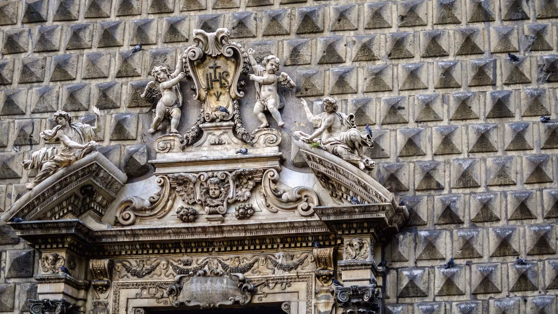 Admire intricate Baroque sculptures at the entrance of Gesù Nuovo Church in Naples.