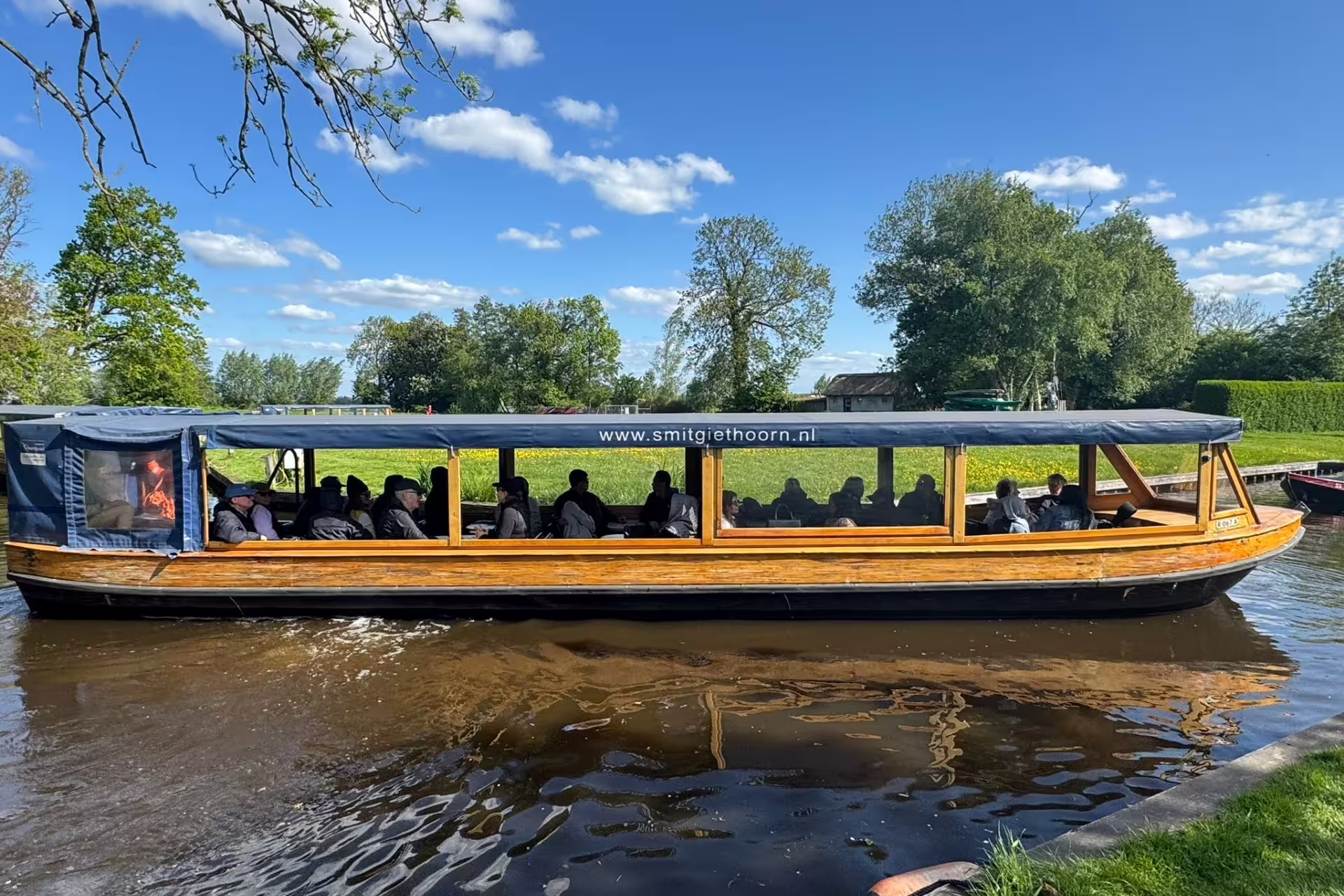 Covered canal cruise boat in Giethoorn village, included on Amsterdam Keukenhof and Giethoorn day trip