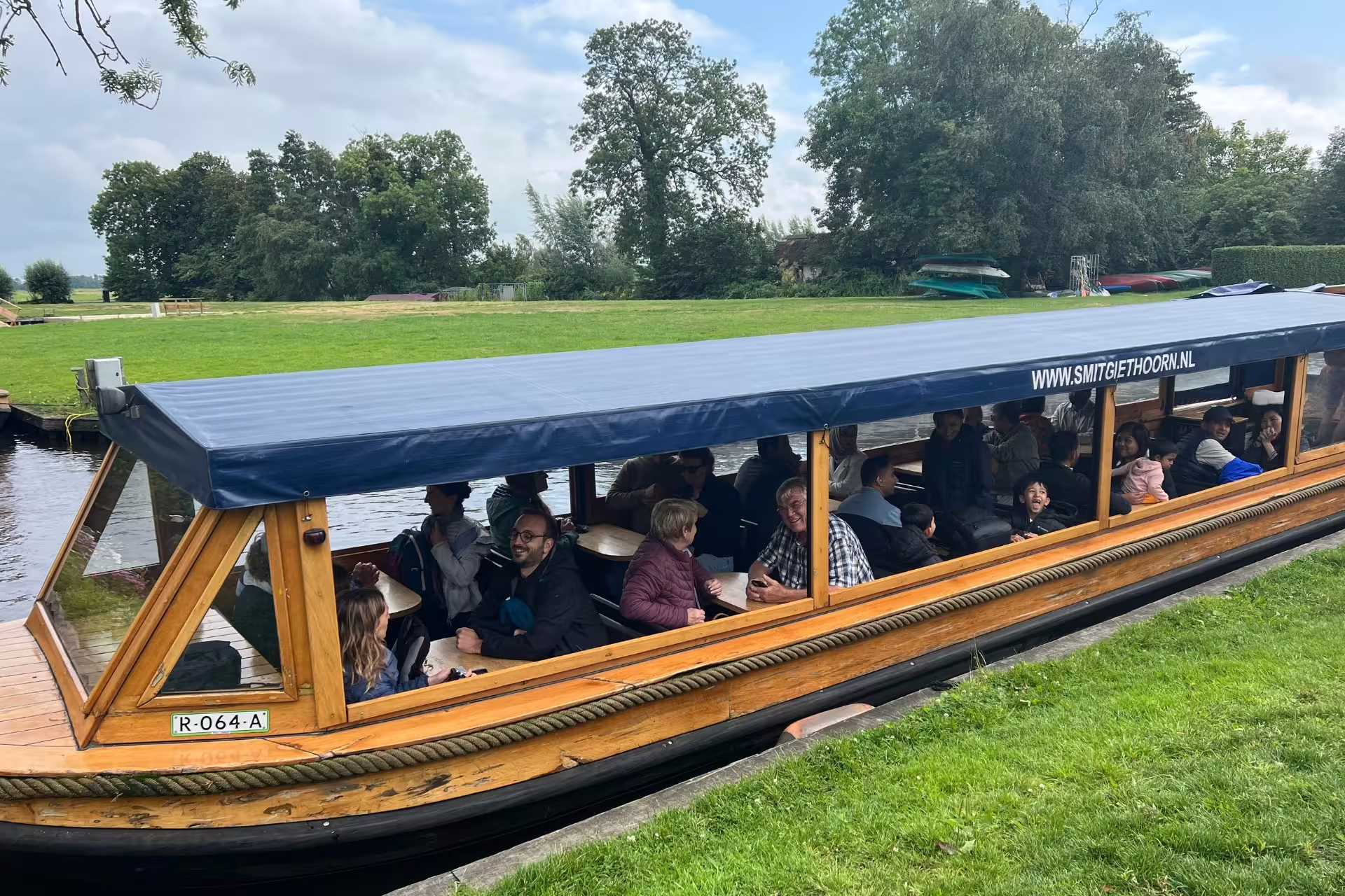 Covered boat canal cruise in Giethoorn from Amsterdam day trip, passengers enjoying Dutch waterways