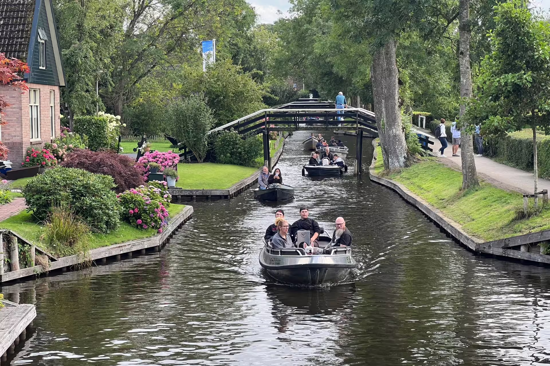 Giethoorn canal cruise with boats under bridge on Amsterdam Zaanse Schans Volendam and Giethoorn tour