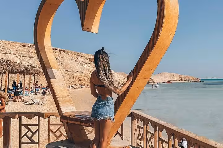 Traveler posing in heart frame on Giftun Island beach, Hurghada sea trip with lunch and water sports