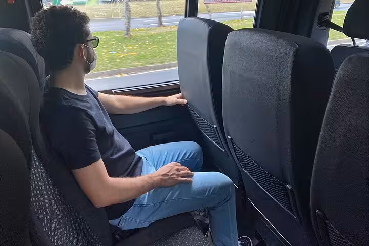 Passenger enjoying a comfortable ride in a private transfer from GIG Airport to Barra da Tijuca hotels.