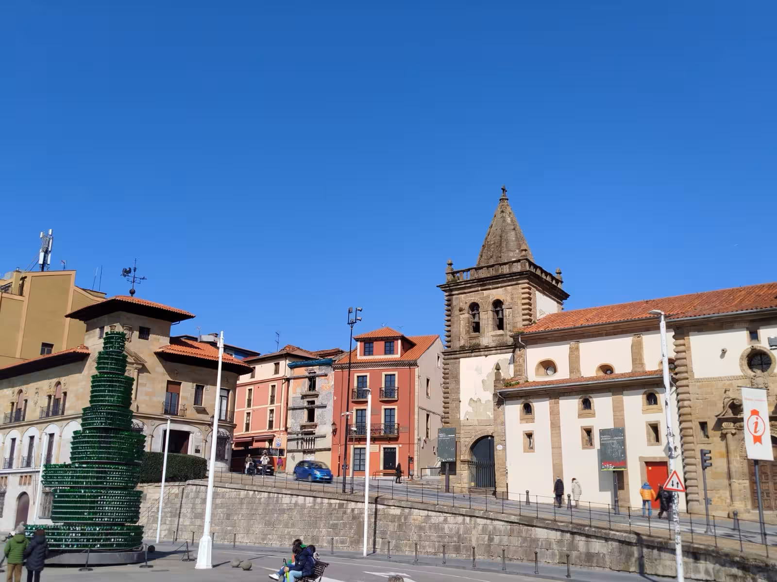 Charming historical buildings under clear blue skies in Gijon, Spain during a cultural city bus tour.