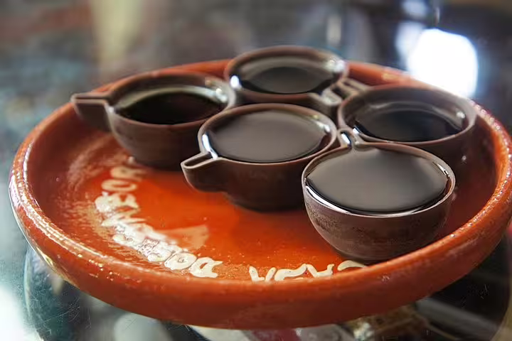 Traditional Ginjinha liqueur in chocolate cups served on a terracotta plate, featured in Obidos Nazare Alcobaca private tour.