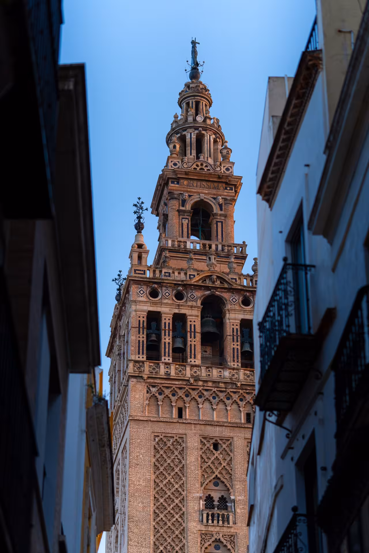 Giralda bell tower seen from a narrow street on a free walking tour in Seville historic center, Spain