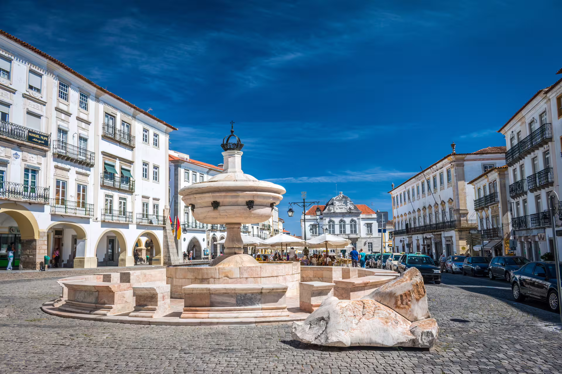 Historic Giraldo Square in Évora, featuring a central marble fountain surrounded by picturesque medieval architecture.