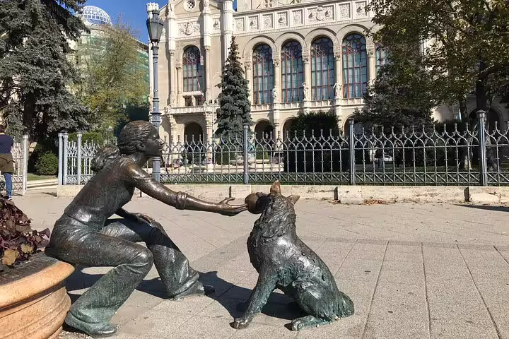 Girl with dog bronze statue near Vajdahunyad Castle in Budapest, a highlight on modern private city tours