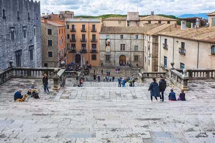 View from the steps of Girona Cathedral overlooking a bustling plaza on the Hello Girona city walk.