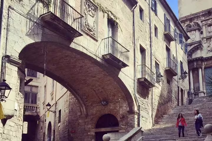 Historic stone archway and steps in Girona's old town, perfect for exploring medieval architecture on a private tour.