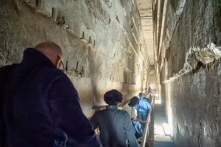 Tourists in narrow corridor inside a Giza pyramid, using skip-the-line entry ticket for quick access