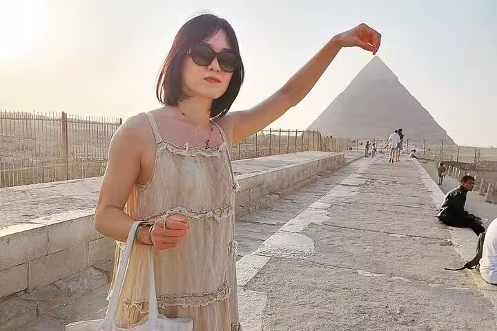 Visitor posing with Great Pyramid of Giza on all-inclusive guided tour, with Saqqara and Memphis day trip