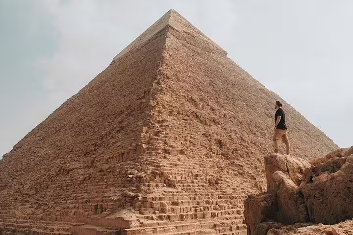 Close-up of the Great Pyramid of Giza with visitor, Port Said to Cairo excursion including Nile River lunch
