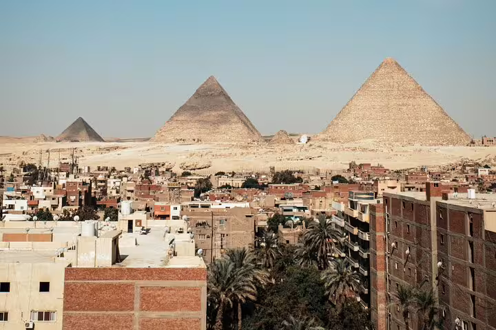 Panoramic view of Giza pyramids above Cairo rooftops, must-see highlight on Giza Pyramids day tour from Cairo