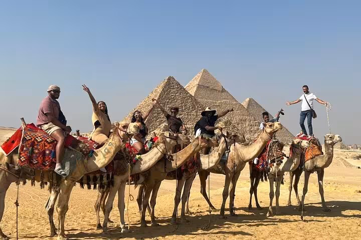 Camel ride group at the Giza Pyramids on a private tour, with panoramic Sahara desert views in Cairo