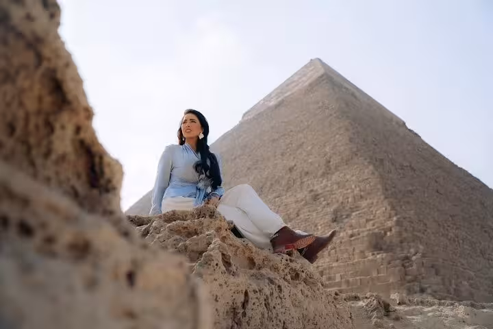 Traveler seated by the Great Pyramid of Giza on a half-day private guided tour in Cairo, Egypt