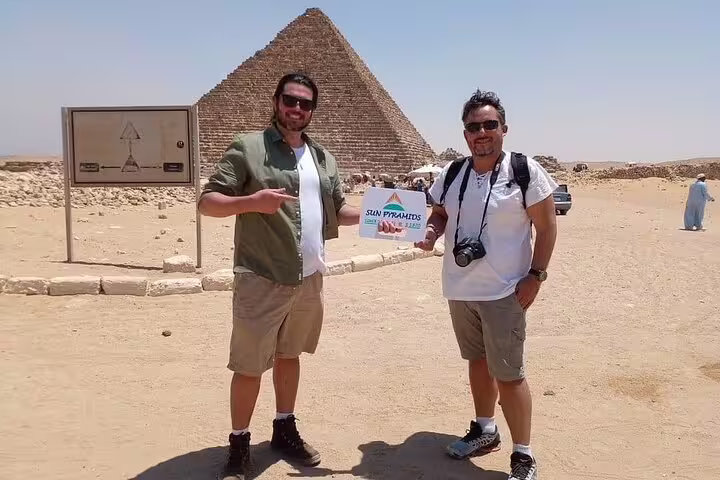 Guests pose at Giza with a pyramid backdrop during a private guided Giza Pyramids tour from Cairo with guide