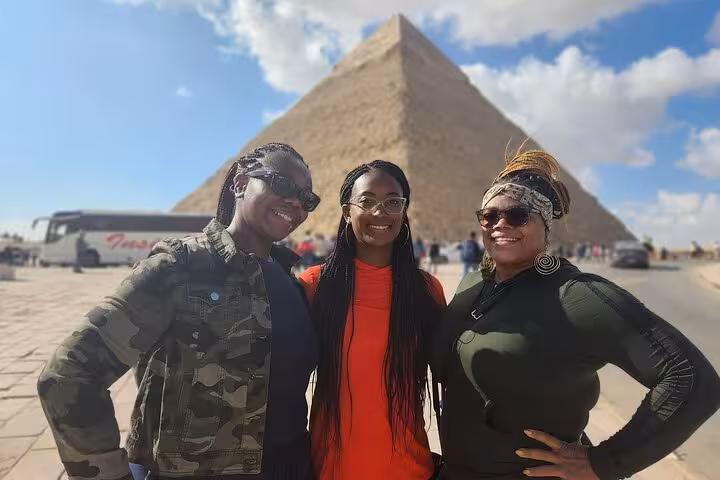Three friends pose happily in front of the Great Pyramid of Giza, highlighting a memorable private tour experience.