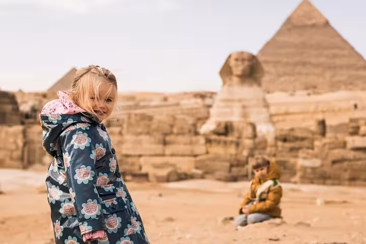 Family photo at Giza Plateau with Great Sphinx and pyramids, a must-see stop on Cairo pyramids and museum tour