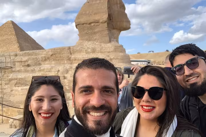 Happy travelers selfie with the Great Sphinx and Giza Pyramid on a private tour with guide in Cairo, Egypt