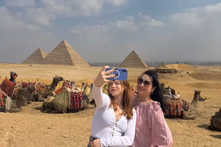 Tourists take a selfie at Giza Pyramids with camels, private Giza & Sphinx tour with camel ride Cairo