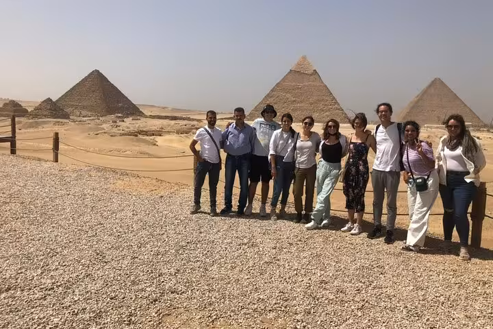 Small group at Giza Plateau viewpoint on a private pyramids tour featuring panoramic desert views near Cairo