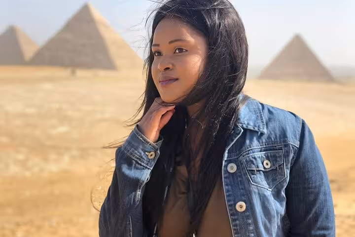 Traveler posing near Giza Pyramids on private tour with Sphinx visit and optional ATV quad bike desert adventure