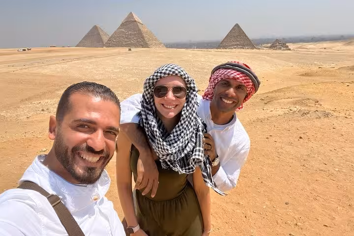 Happy travelers with local guide at Giza Pyramids viewpoint on private tour with panoramic desert views, Cairo