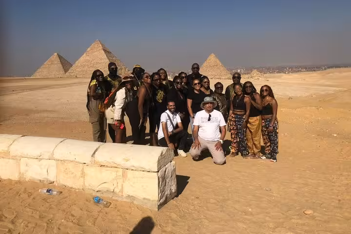 Tour group posing at Giza Pyramids panoramic viewpoint in Cairo desert, ideal for private guided excursions