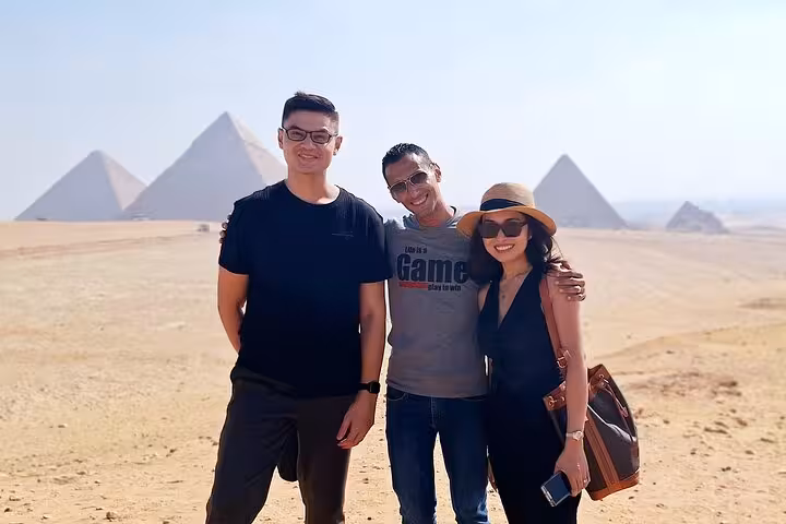 Group enjoying a sunny day with the iconic Giza Pyramids in the background on a private tour.