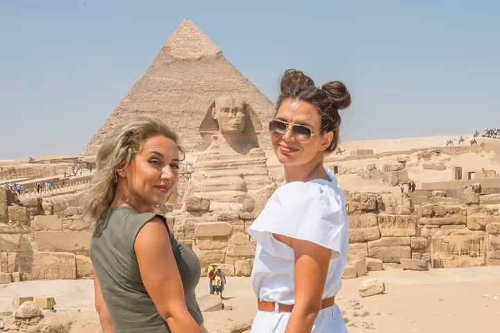 Visitors pose by the Great Sphinx and Pyramid of Khafre with Giza Pyramids skip-the-line site access