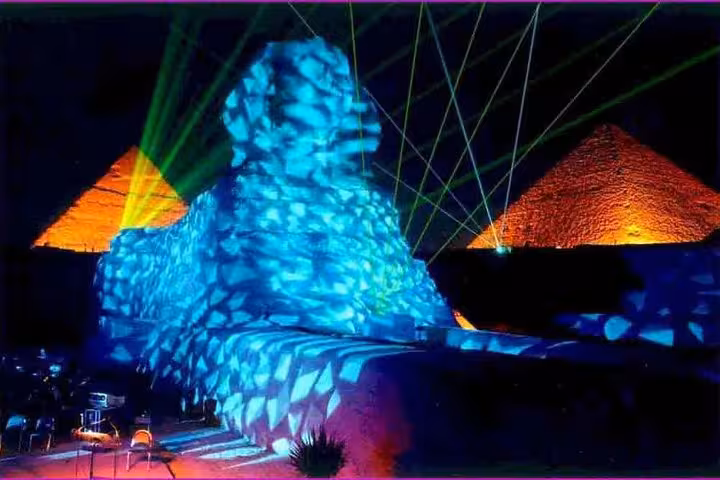 Laser beams and blue-lit Sphinx with glowing pyramids during Giza Sound and Light Show, evening experience Cairo