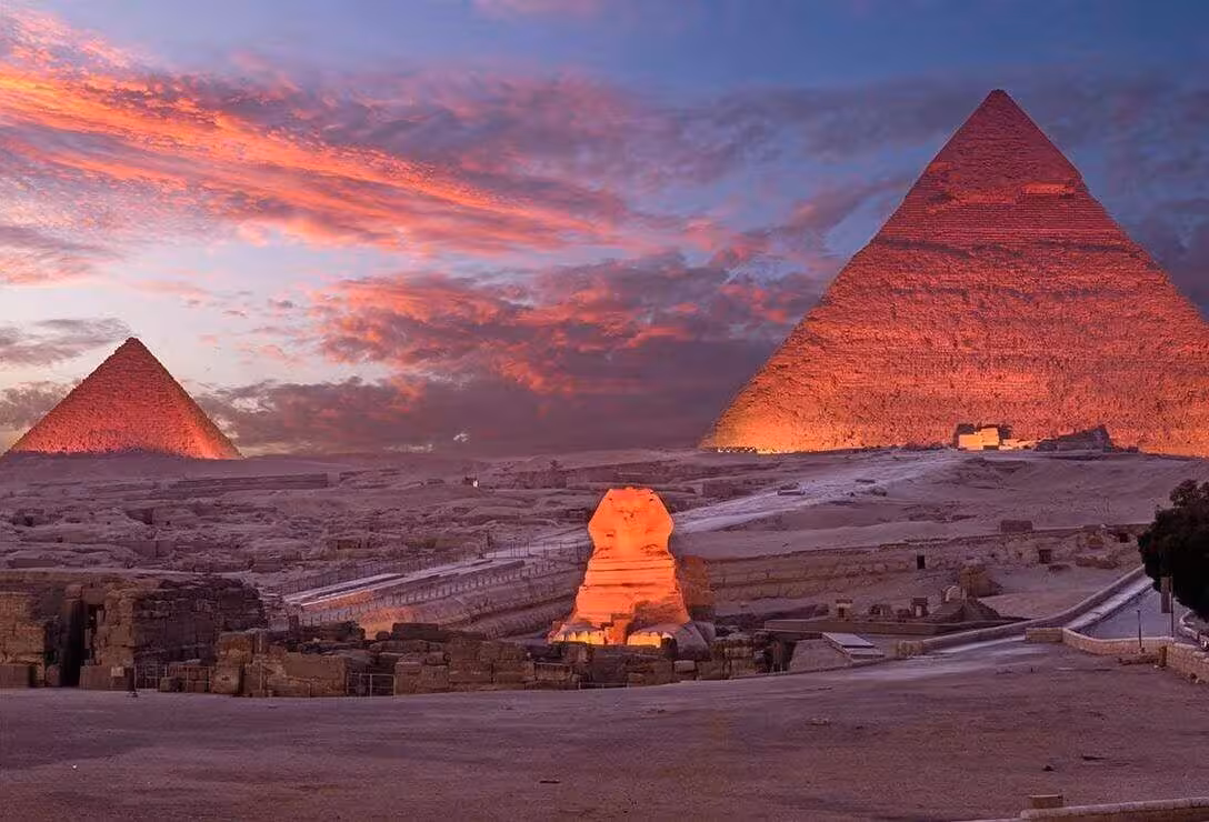 Giza Pyramids and Great Sphinx glowing at sunset during Sound and Light Show tour in Cairo, Egypt