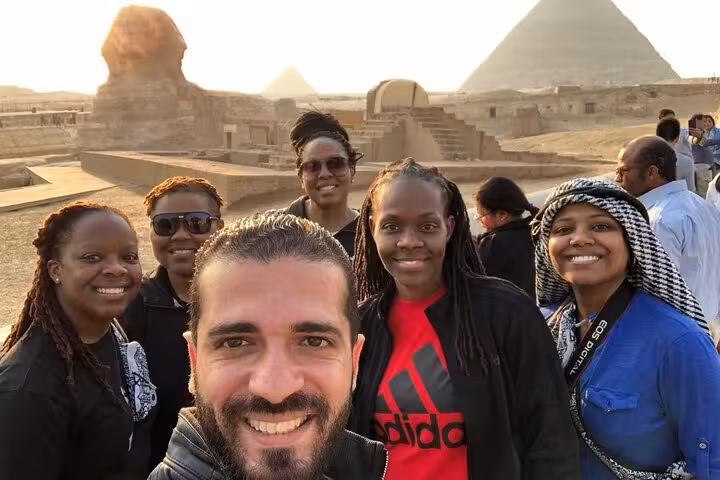 Tour group selfie at Giza Plateau with Great Sphinx and pyramids at sunset, Cairo private tour experience