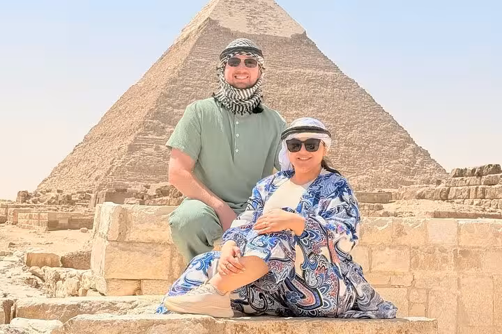 Tourists posing at the Great Pyramid of Giza on a half-day Giza Pyramids and Sphinx tour with lunch