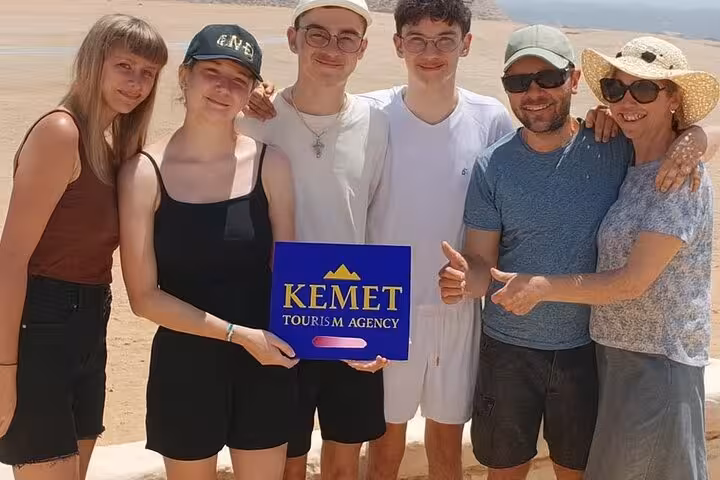 Happy group holding Kemet Tourism Agency sign on a Giza, Saqqara and Memphis full-day tour with hotel pickup