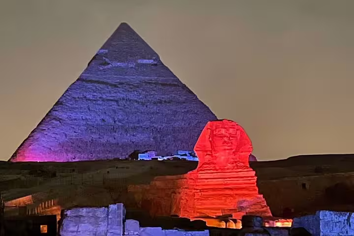 Giza Sound and Light Show at night with Sphinx glowing red and Great Pyramid illuminated in Egypt