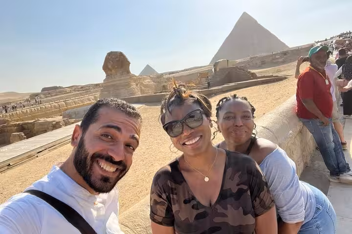 Happy group selfie at Giza Sphinx viewpoint with pyramids, part of private guided tour and GEM visit