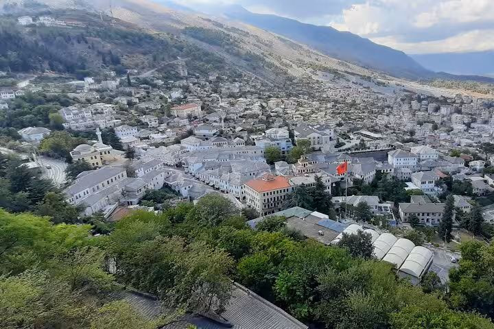 Discover the panoramic view of Gjirokastër, Albania, showcasing its historic architecture nestled in mountain landscapes.