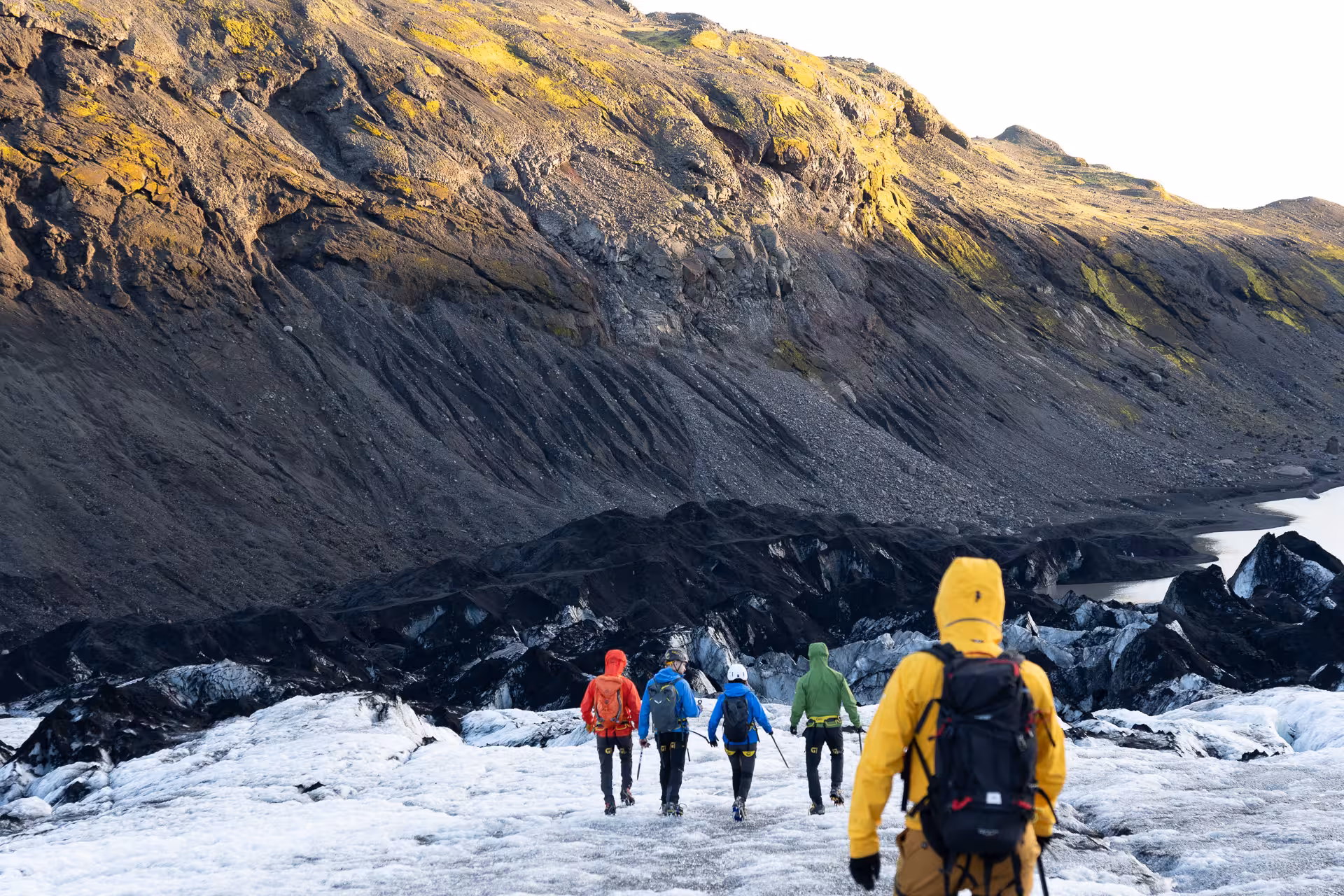 Guided group hiking on Sólheimajökull glacier with ice axes, exploring Iceland’s South Coast glacial landscape