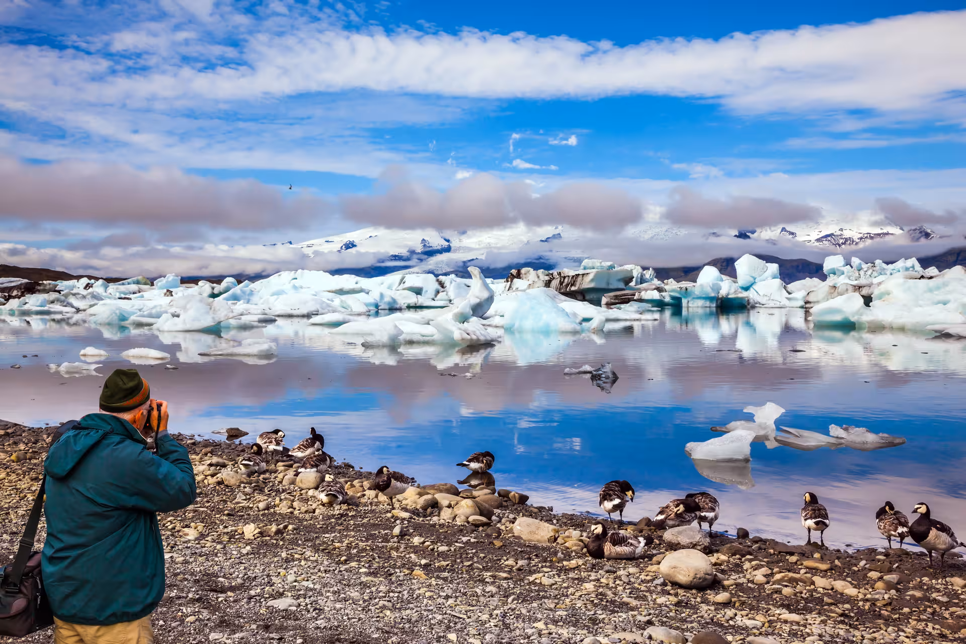 Photographer capturing stunning icebergs and serene waters at Glacier Lagoon, perfect for a private tour experience.