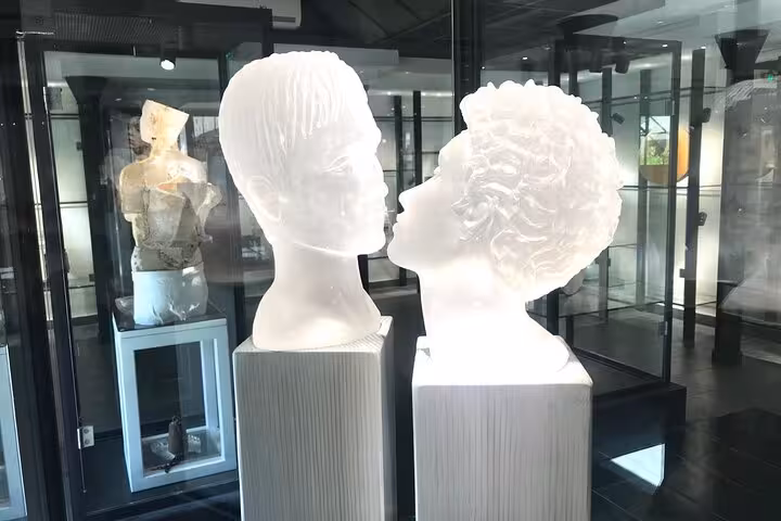 Elegant glass sculptures of two faces in a modern art gallery, highlighting intricate craftsmanship and design.