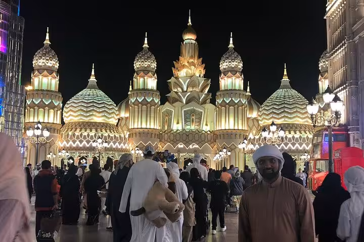 Global Village Dubai night scene with illuminated domes and crowds, included with UAE attraction ticket pass